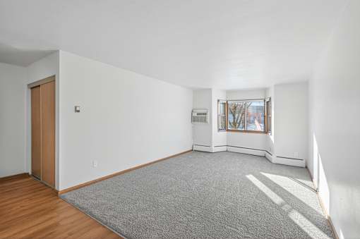 A room with a grey carpet and a wooden door.