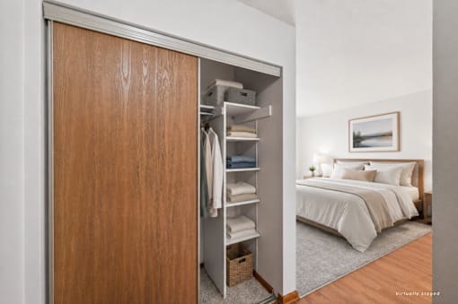 A bedroom with a large bed and a wooden wardrobe.