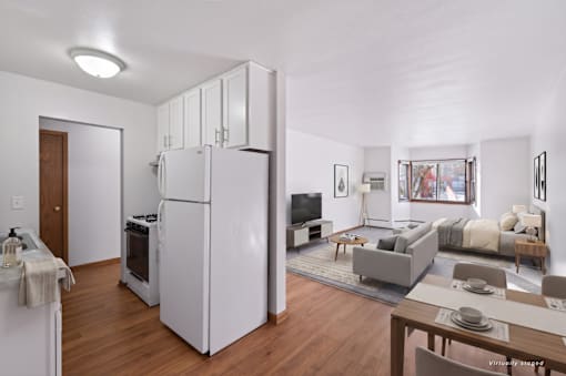 A kitchen with white appliances and wooden floors.