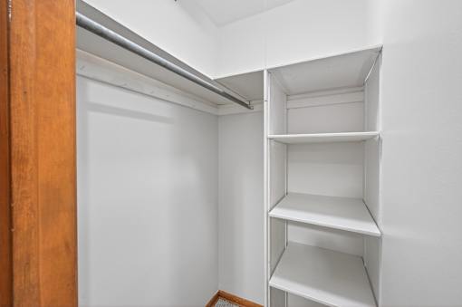 A white closet with shelves and a door.