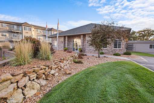 A house with a stone wall in front of it.