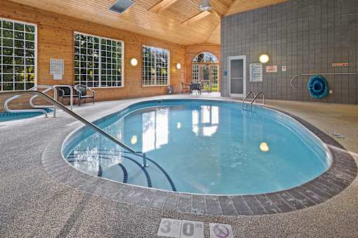 A round indoor swimming pool with a glass wall surrounding it.