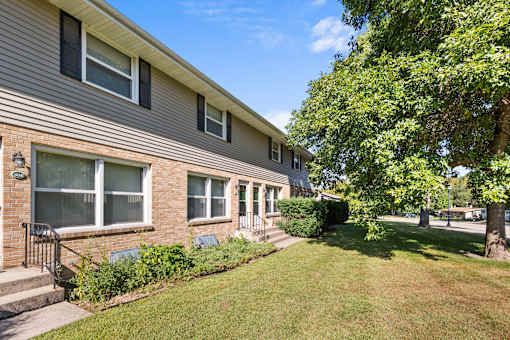 A house with a green lawn in front.