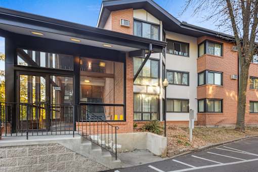 the facade of a new apartment building with glass doors and a staircase