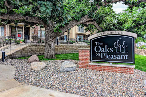 the oaks on pleasant sign in front of trees and rocks