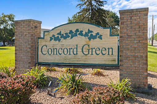 a sign for concord green in front of a park