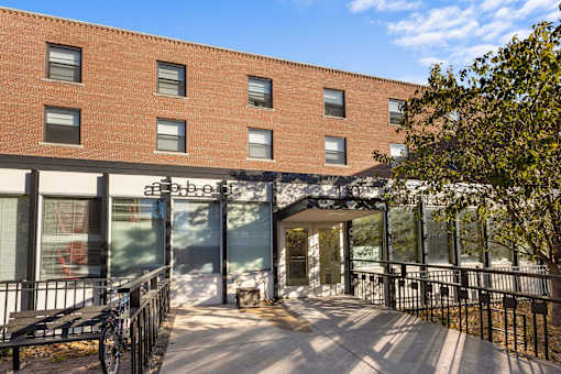 a large brick building with a patio and a bench