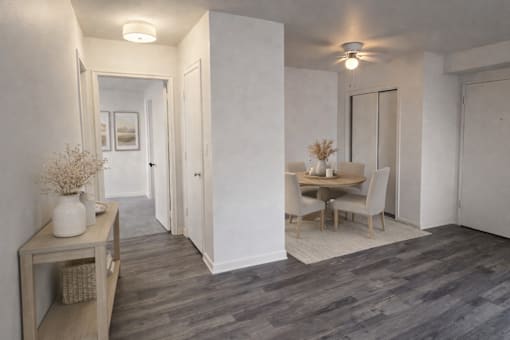 A room with a dining table and chairs.