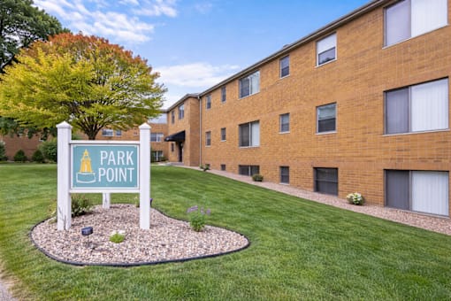 A sign that says Park Point stands in front of a brick building.
