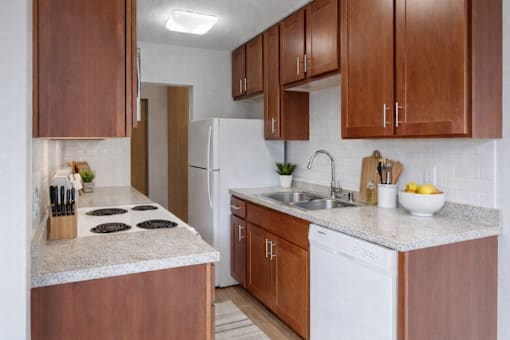 A kitchen with brown cabinets and a white fridge.