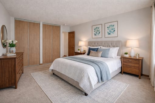 A bedroom with a large bed, a nightstand, and a dresser.