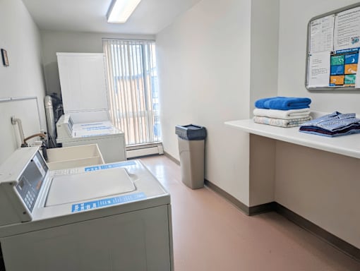 A medical office with a white cabinet, a blue towel, and a poster on the wall.