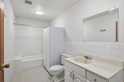 A white bathroom with a toilet, sink, and bathtub.