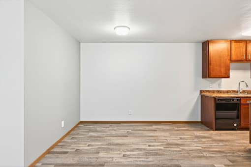 A kitchen area with a wooden floor and a small kitchenette.