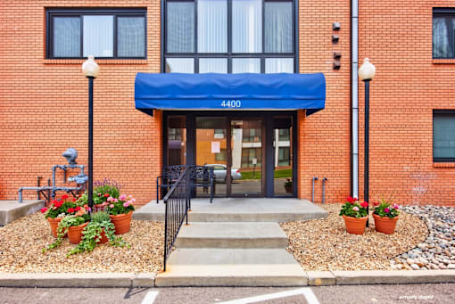 The entrance to a building with a blue awning and a sign that reads 4400.