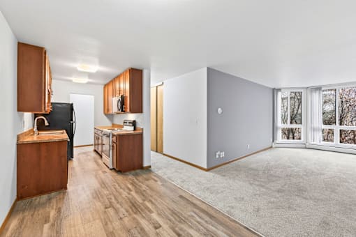 A room with wooden floors and a black refrigerator.