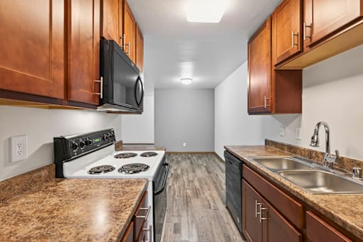 A kitchen with a stove, microwave, and sink.