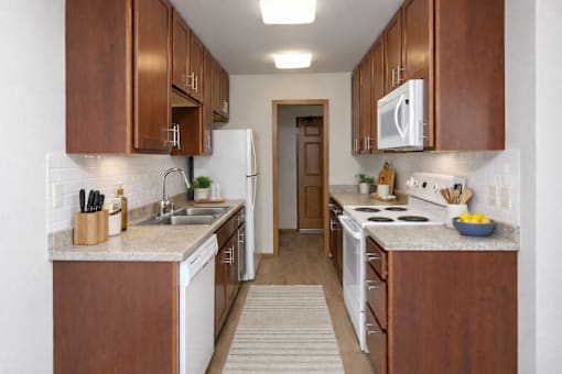 A kitchen with brown cabinets and white appliances.