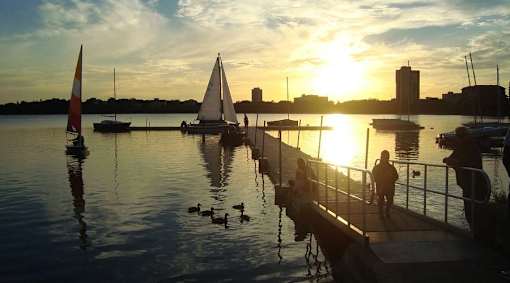 A serene sunset view at a marina with people enjoying the view.