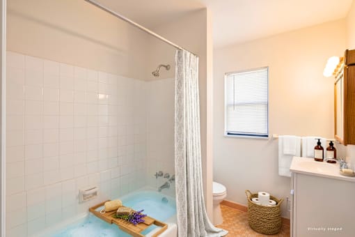 A bathroom with a shower curtain and a bathtub filled with blue water.