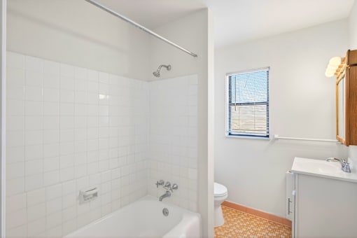 A white bathroom with a tub, toilet, and sink.