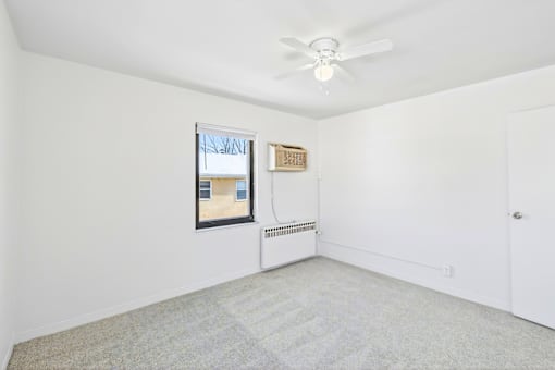A room with a ceiling fan and a window.