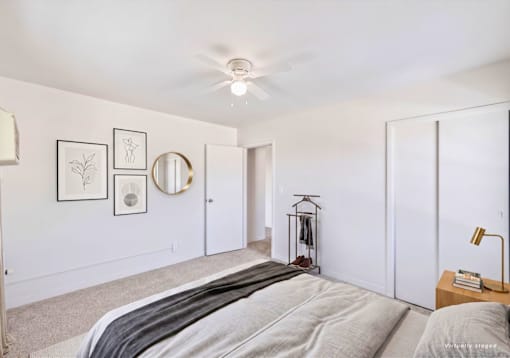 A bedroom with a bed, a dresser, and a mirror.