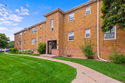 A brick building with a green lawn in front.