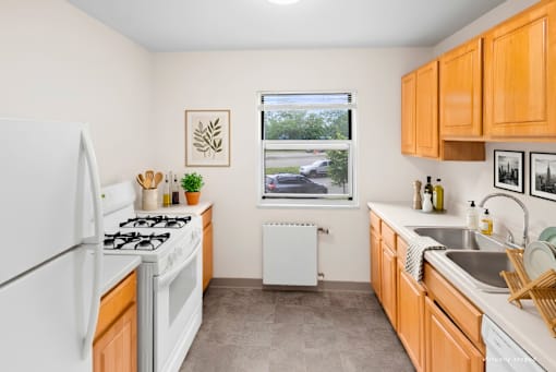 A kitchen with white appliances and wooden cabinets.