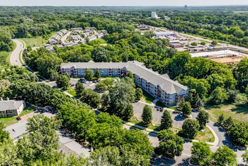A large building surrounded by trees is the main focus of this aerial image.