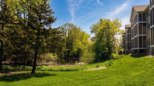 A serene landscape with a building on the right and trees in the background.