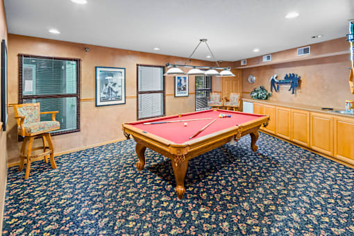 A pool table in a room with a blue carpet.