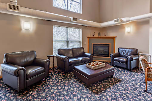 A living room with a fireplace and leather chairs.