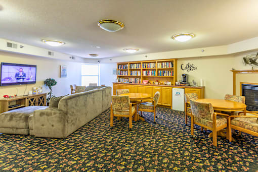 A living room with a couch, chairs, and a television.