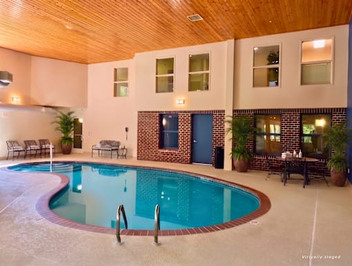 A large indoor swimming pool with a wooden ceiling and a blue door.