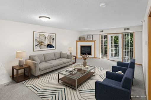 A living room with a grey couch, a coffee table, and a painting on the wall.