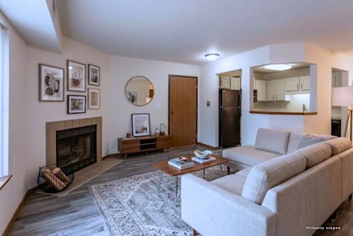 A living room with a grey couch, a fireplace, and a coffee table.