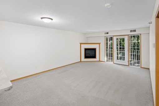 A room with a grey carpet and a television set.