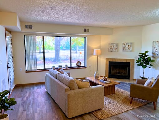 A living room with a couch, a fireplace, and a large window.