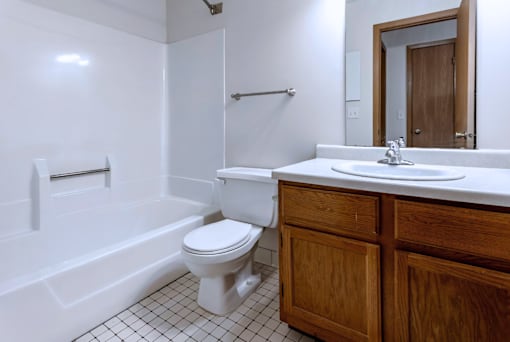 A white toilet sits in a bathroom next to a white sink.