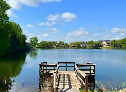 A wooden dock extends into a calm lake.