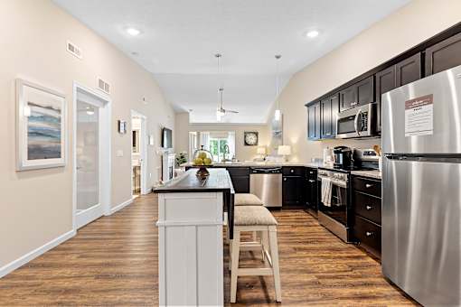A kitchen with a white island and stainless steel appliances.