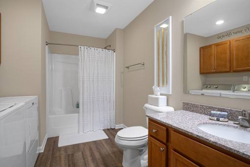 A bathroom with a toilet, sink, and shower.