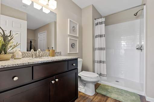 A bathroom with a toilet, sink, and shower.