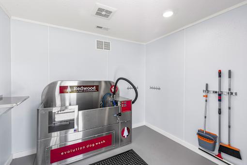 A redwood dog wash machine is in a white room.