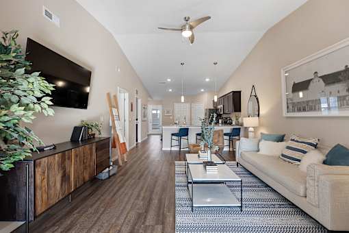 A living room with a white couch, a wooden cabinet, and a ceiling fan.