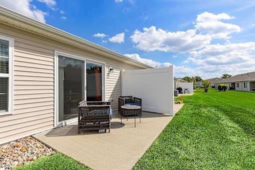 A house with a patio and a white wall.