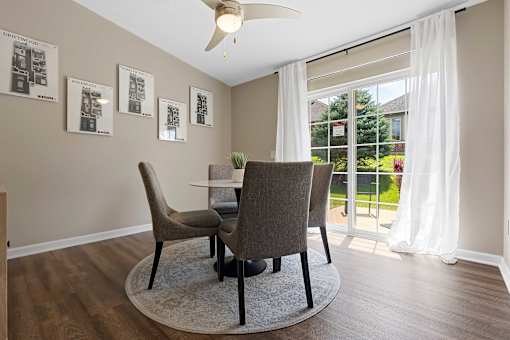 A dining room with a table and chairs.