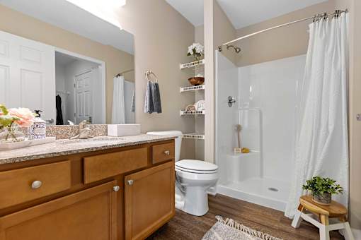 A bathroom with a toilet, sink, and shower.