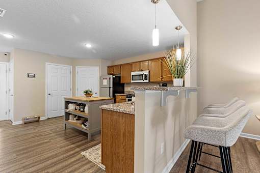 A kitchen with a bar stool in front of it.